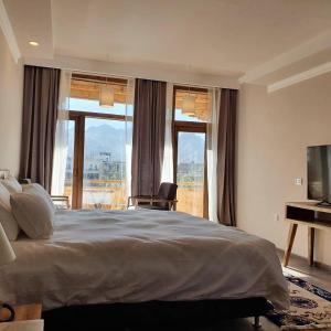 列城Hotel Amanthi Ladakh的一间卧室配有一张大床和电视