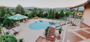 盖夫盖利亚Villa Katerina & Pool的享有带椅子和遮阳伞的游泳池的上方景致