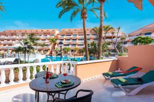 美洲海滩Tenerife South Apartments的一个带桌椅的阳台和一个度假村