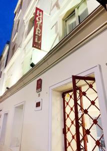 巴黎Hotel Bellevue Montmartre的门上方标有标志的白色建筑