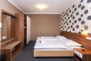 Bučovice阿卡达酒店的一间卧室配有一张带木制床头板的床