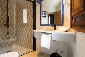 托莱多索尔酒店的一间带水槽、镜子和淋浴的浴室