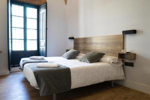 Puebla de AlcocerBalhondo Open Village的一间卧室设有两张床和木制床头板