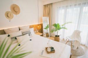 邦劳Ultra Mint Dive Resort的白色卧室配有白色的床和植物