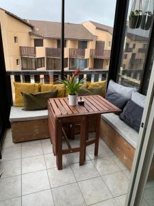 拉卡诺奥肯Appartement vue sur mer, 30m de la plage的阳台设有带木桌和长凳的天井。
