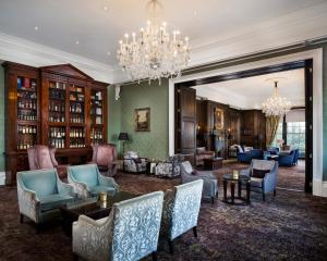 利兹Oulton Hall Hotel, Spa & Golf Resort的客厅配有椅子和吊灯。