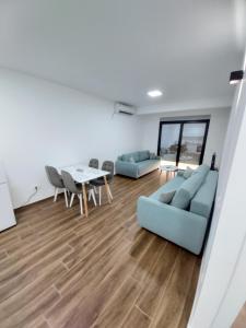 多布拉沃达Apartmani Aida的客厅配有2张蓝色的沙发和1张桌子