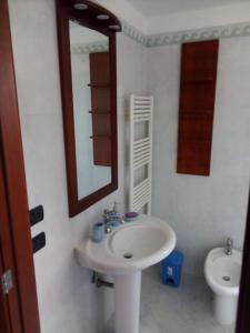 斯佩基亚Attico Matine的一间带水槽、镜子和卫生间的浴室