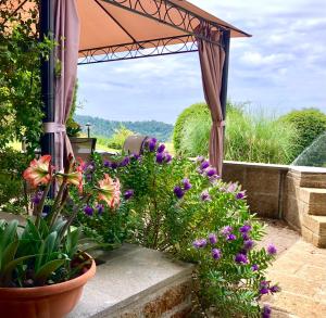 坎帕尼亚诺·迪罗马瑟兰拉度假屋的一座种有紫色花卉和遮阳伞的花园
