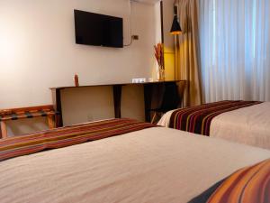 拉巴斯萨迦纳迦酒店的酒店客房设有两张床和一台平面电视。
