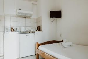 费索斯Filippos Rooms Afissos的一间白色的小厨房,在房间内配有一张床