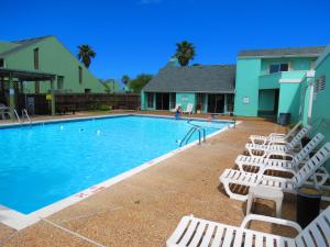科珀斯克里斯蒂Multi Resorts at Puente Vista的一座带白色躺椅的游泳池,位于大楼旁