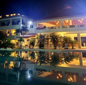 巴亚希贝Residencial Paraiso Bayahibe的一座大型建筑,晚上设有游泳池