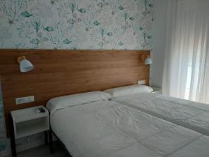坎加斯德穆拉索罗德拉米尔2A酒店的一间卧室配有一张带木制床头板的床