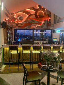 特拉维夫180 Boutique Hostel的餐厅设有酒吧,配有椅子和桌子