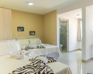 戈亚尼亚Hotel Areião的客房设有两张床和一间浴室。