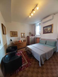 戈尔贡佐拉Appartamento "Da Mamma Agnese"的一间卧室配有一张床、一张沙发和一把椅子