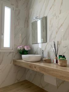 莫诺波利Le dimore di Vittorio Emanuele的浴室设有水槽和镜子,位于柜台上