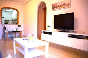 瓜尔达马尔·德尔·塞古拉Los Naranjos的客厅配有电视和白色桌子。