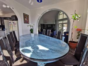 圣马丁Vila Angela Felix的一间设有玻璃桌和椅子的用餐室