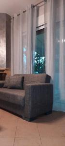 斯卡拉卡里拉奇斯Seaside Deluxe Apartment的靠窗前的沙发,窗帘