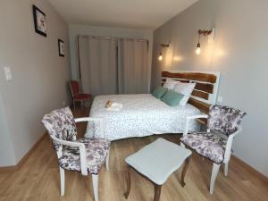 GrazacLes Hauts de Grazac的一间卧室配有一张床和两把椅子