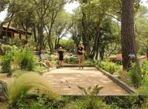 韦基奥圣露西港口Domaine de la Testa的两个人在花园里玩多米诺骨牌游戏