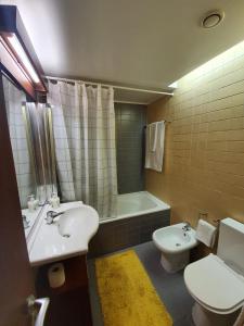 孔波尔塔T1 Troia Resort - Praia Mar的浴室配有盥洗盆、卫生间和浴缸。