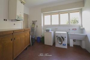 萨莱马拉西诺CASA VACANZE GLI ULIVI DEL LAGO的厨房配有洗衣机和水槽