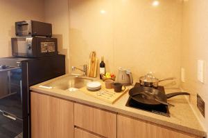 东京MONday Apart Premium UENO OKACHIMACHI的一间带水槽和微波炉的小厨房