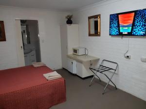 塔姆沃思克鲁尼欧汽车旅馆的客房设有床、椅子和微波炉