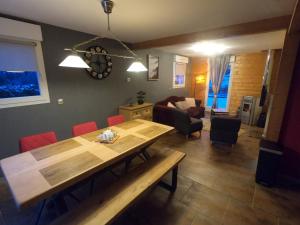 莱托利Le Flocon Vosgien的客厅配有木桌和红色椅子