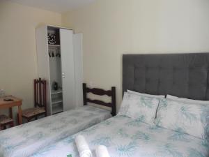 彼得罗波利斯Aconchego Valparaíso的一间卧室配有一张带灰色床头板和白色床单的床。