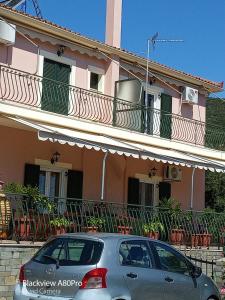 PoulátaCHRYSPY Toulatos Studios的停在粉红色房子前面的汽车