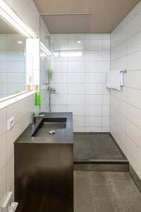 梅明根JOESEPP´S HOTEL am Schweizerberg的浴室设有黑色水槽和镜子