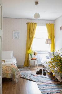 KinnulaKarkausmäen Kammari的一间卧室设有两张床,窗户配有黄色窗帘