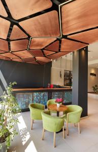 阿尔杰什河畔库尔泰亚波萨达酒店的一间设有绿色椅子和木制天花板的用餐室