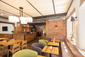 梅明根JOESEPP´S HOTEL am Hallhof的餐厅设有木桌和椅子,拥有砖墙