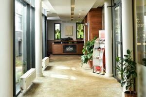 萨拉热窝Heritage Hotel Krone的带有盆栽植物和书桌的办公走廊