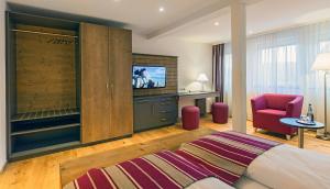 费尔德伯格瓦尔德克酒店的酒店客房带一张床、一台电视和一把椅子