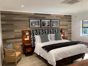 维多利亚瀑布Pamarah Lodge的一间卧室设有一张大床和木墙