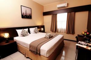 沙拉迪加彭多克鲁奥萨玛旅馆的酒店客房设有床和窗户。