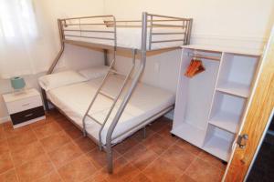 代尔特布雷Casa rural Antich Delta del Ebro的带冰箱的小客房内的双层床