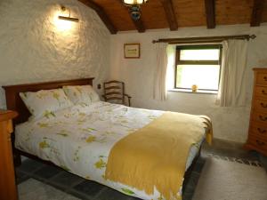 TurriffSilverstripe的一间卧室配有一张带黄色棉被的床和窗户