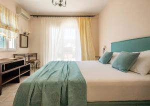 波罗斯Aegean Villas的一间卧室配有一张床、一张书桌和一个窗户。