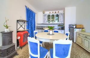 奥米沙利Holiday house SEAFRONT的一间带桌子和蓝色椅子的用餐室