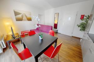 苏黎世HIT欧瑞康出租公寓的一间带桌子和红色椅子的用餐室