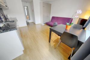 苏黎世列特齐格伦HIT出租公寓的客厅配有桌子和紫色沙发