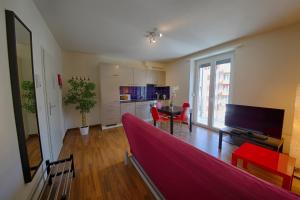 苏黎世HIT欧瑞康出租公寓的一间带红色沙发的客厅和一间厨房