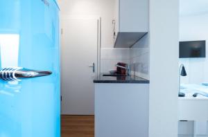 苏黎世HITrental Altstetten Apartments的白色的厨房设有水槽和炉灶。